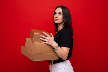 Young woman with paper boxes on red background