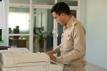 A Professional level Thai government officer, Civil servant using photocopiers at work.