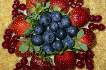 Top of cake decorated with mixed berries. Napoleon, blueberries, strawberries and redcurrant. Soft selective focus, copy space.