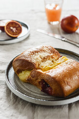 Breakfast with Twisted Bun with cheese and jam, juice and oranges. Red-Jam and Cheese Danish. Selective focus