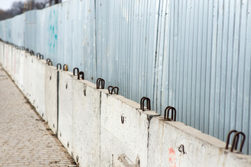 metal fence with concrete slabs at the construction site in the city
