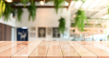 Empty wooden table top with lights bokeh on blur restaurant background.
