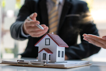 The real estate agent is explaining the house style to the clients who come to contact to see the house design and the purchase agreement.