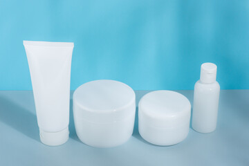 A set of cosmetic tubes for cream, different sizes, clean, white without inscriptions, on a gray-blue background, mockup, template