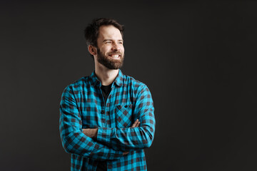 Fototapeta premium Bearded brunette man in shirt smiling and looking aside