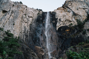 Fototapeta na wymiar Tall waterfall on huge mountain cliff