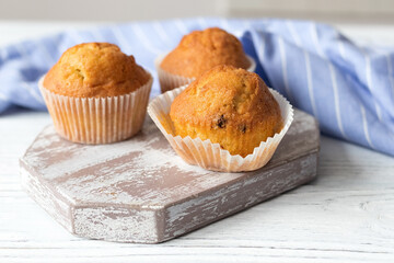Appetizing homemade muffins on a white wooden table
