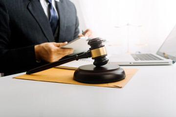 Justice and law concept.Male judge in a courtroom with the gavel, working with, computer and...