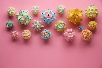 Set of multicolor handmade modular origami balls or Kusudama Isolated on pink background. Visual...