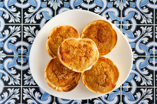 Traditional Portuguese pastry called Queijada de Sintra on portuguese tiles background