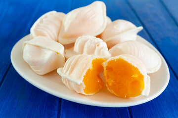 Traditional portuguese egg yolk sweets called Ovos Moles de Aveiro on blue wooden table