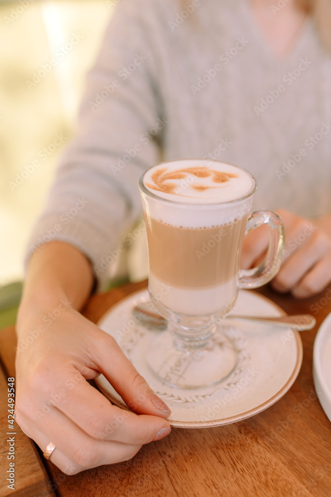 Wall mural female hands holding cup of hot latte coffee cappuccino