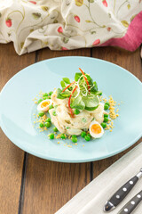 salad with squid rings, eggs and mayo on wooden table