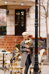 Woman in beret and glasses with a bouquet of flowers