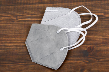 Two gray face masks on a wooden background