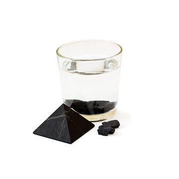 Water with shungite in a glass on a white background.