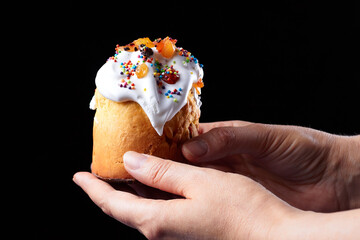 Female hands carrying delicious Easter cupcake (sweet bread Orthodox kulich, paska) on dark background