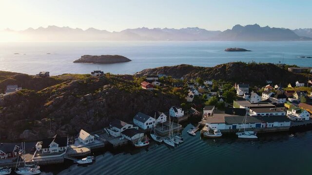 Aerial view of a village, in Lofoten archipelago, sunset, in Norway - reverse, drone shot