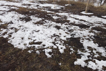 Countryside in early spring. Large plowed land or field with melting snow and thawed patches. Thawed patches. Nature wakes up.