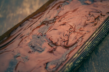Close up of a texture of a chocolate sauce on a chocolate cake.