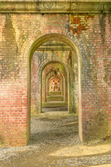 A series of brick arches of ancient brick aqueduct at Nanzen-ji, at Zen Buddhist Temple in Higashiyama District, Kyoto, Japan. Japanese women with kimono visit the temple in springtime.