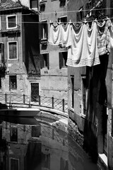 Canal in Venice with old houses and airing linen