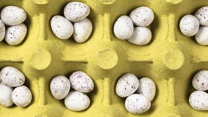 Small white eggs in yellow egg tray. Easter background. Top view