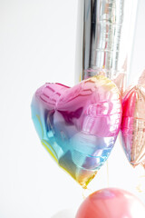 multicolored balloon in the shape of a heart on a white background. Birthday, Valentine's Day, Mother's Day. Balloons for a photo shoot