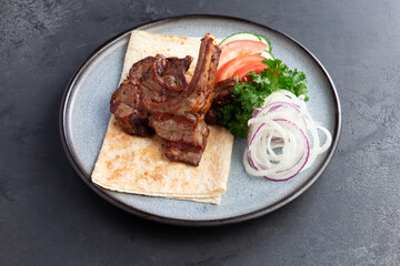 Lamb rack in a plate with vegetables.