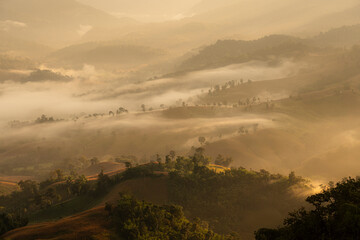 Silhouette of orange sunlight, slice mist and layers of small hills at Kao Hua Mot in the morning, Tak Provice, Thailand.