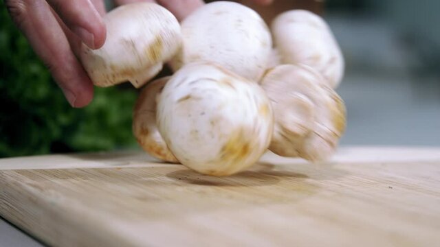 champignons falling slow motion, Raw mushrooms champignons are on a wooden cutting Board