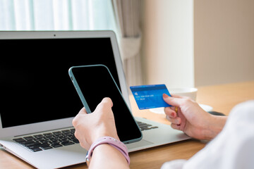 Businessman hands touch on the mobile and paying with credit card online while making order online shopping via the internet.