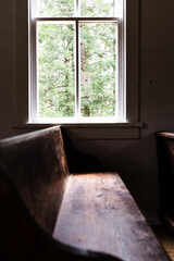 Fototapeta premium sunlight spilling through a church window, lighting the pew