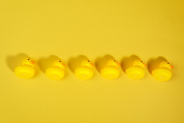 yellow rubber ducks on a yellow background. Minimal summer concept.