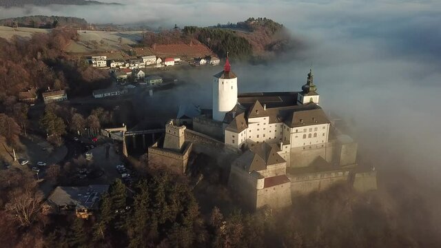 Cinematic aerial drone footage of the charming historical quaint old medieval European Burg Forchtenstein Castle with clouds and fog in Burgenland Austria