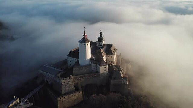 Cinematic foggy morning aerial drone footage of the charming historical quaint old medieval European Burg Forchtenstein Castle in Burgenland Austria