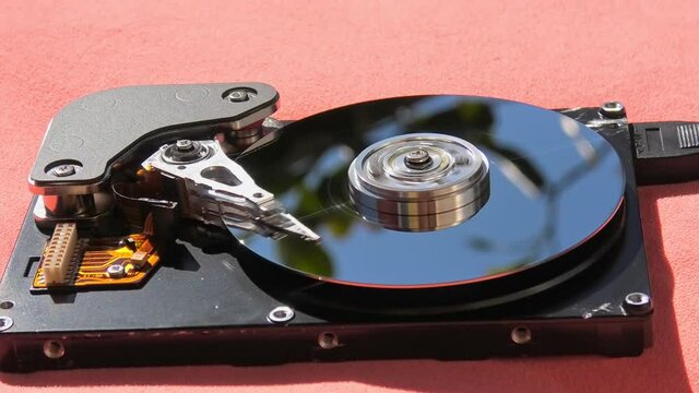 close up of interior of a a big HDD hard disk drive writing data on the support with its head. PATA data type disk.