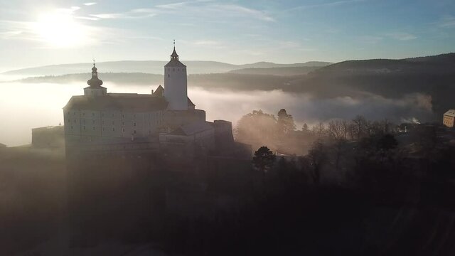 Cinematic aerial drone view of the charming historical quaint old medieval European Burg Forchtenstein Castle at sunrise, early morning in Burgenland Austria