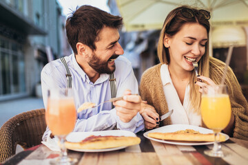 Young couple sitting in a restaurant eating pizza