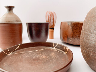 Brown Kintsugi pottery, bizen ware with gold scars repair