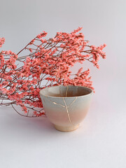 Kintsugi, Japanese Hanami flowers with real gold restored pottery, golden scarsa and cherry blossoms