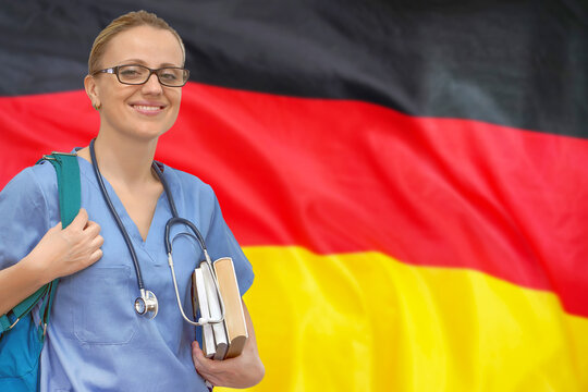 Female student doctor with stethoscope and books in hand on the Germany flag background. Medical education concept. Medical learning in Germany