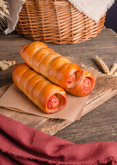 Appetizing fresh culinary pastry - sausages in pastry on wooden