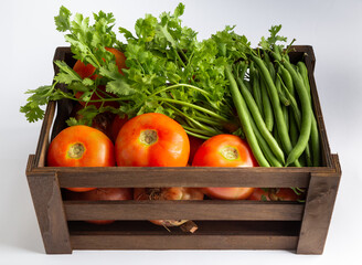Wooden box with fruits and vegetables - Banana Tomato Pod Coriander Mango Orange.