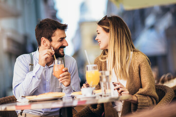 Young couple sitting in a restaurant eating pizza