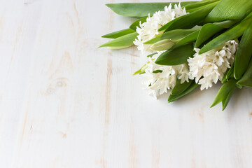 White hyacinths and tulips on white wood