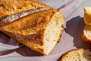 Delicious fresh baked baguette cut on a wooden cutting board