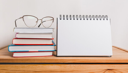 white notepad, books and glasses on workplace. Mock up in copy space office purple background. It is important not to forget the note
