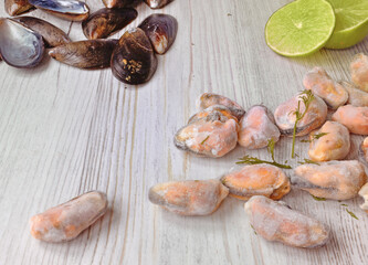 mussel shells, frozen mussels, lime are on a wooden table