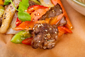 A piece of stewed meat with sesame, vegetables and greens